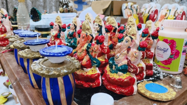 गाय के गोबर से तैयार लक्ष्मी गणेश तैयार करते हुए प्रयागराज की आभा सिंह एवं उनके सहयोगियों का छाया चित्र