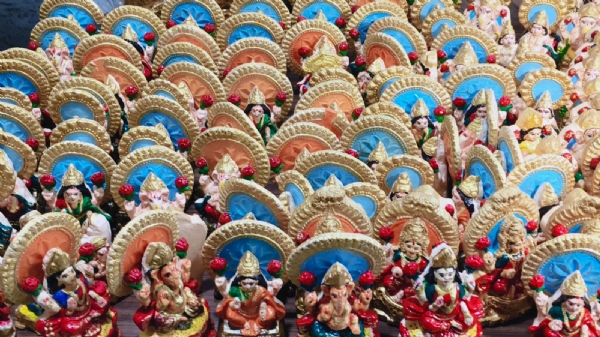 गाय के गोबर से तैयार लक्ष्मी गणेश तैयार करते हुए प्रयागराज की आभा सिंह एवं उनके सहयोगियों का छाया चित्र