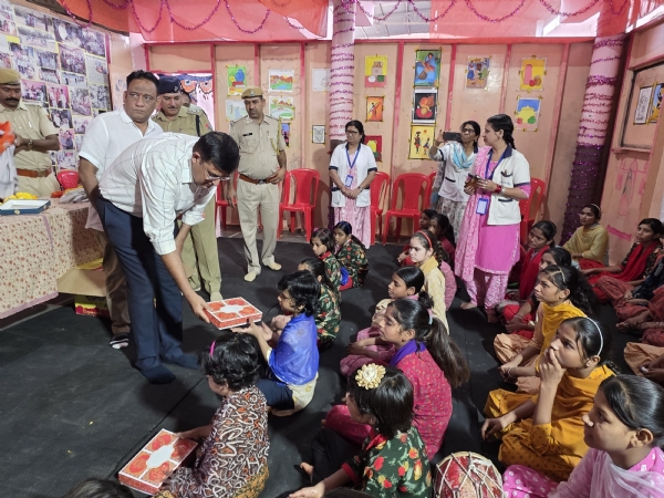 बच्चों को उपहार और मिठाई देते पुलिस अधीक्षक सुधीर जोशी
