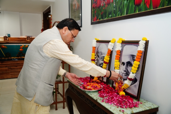 मुख्यमंत्री पुष्कर सिंह धामी महात्मा गांधी और लाल बहादुर शास्त्री  के चित्र पर मुख्यमंत्री आवास में पुष्प अर्पित करते।