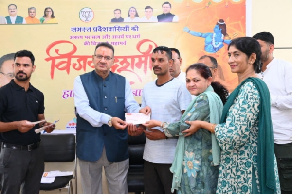 मंत्री गणेश जोशी  शनिवार को कैंप कार्यालय में मसूरी विधानसभा क्षेत्र के आपदा प्रभावित परिवारों को चेक सौंपते हुए।
