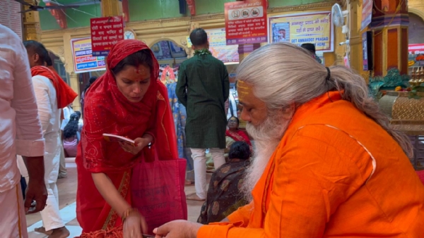 श्रद्धालुओं को धागा देते महंत शंकर पुरी श्रद्धालुओं को धागा देते महंत शंकर पुरी