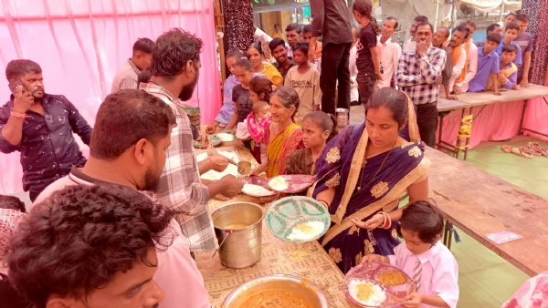 भंडारे में प्रसादी ग्रहण करते हुए लोग।