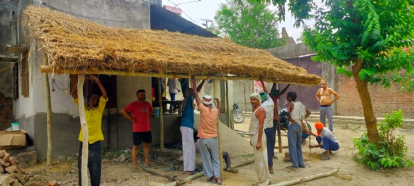गांव में छप्पर रखते लोग गांव में छप्पर रखते लोग