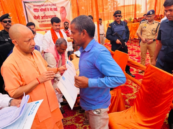 पीड़ित परिवारों को चेक देते मुख्यमंत्री