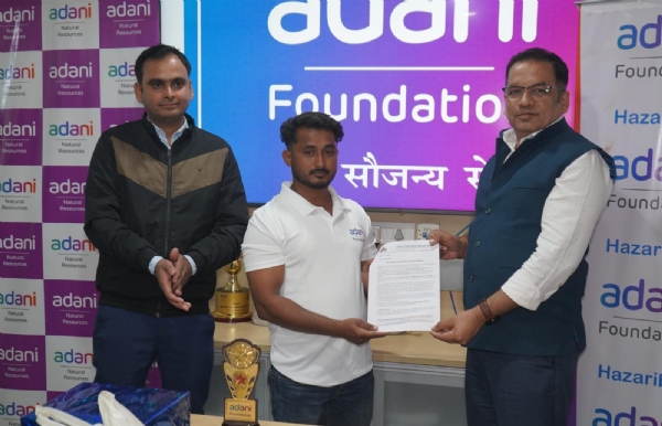 नियुक्‍ति‍ पत्र ग्रहण करते युवक और अदाणी के अध‍िकारियों की तस्‍वीर