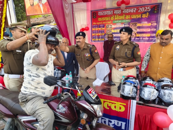 बाइक सवार को हेलमेट पहनाते अधिकारी