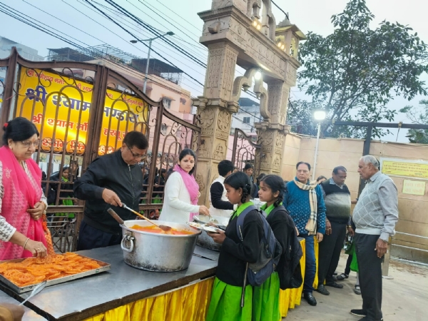 कार्यक्रम में श्रद्धालूओं को खिलाते महाप्रसाद