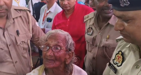 भदोही जिले से आईं 104 वर्षीय वृद्ध महिला को दर्शन कराने ले जाते पुलिसकर्मी।