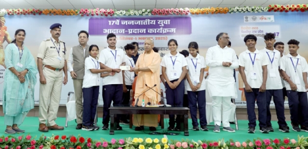 बिरसा मुंडा की 150वीं जयंती कार्यक्रम में माैजूद बच्चे काे सम्मानित करते सीएम याेगी
