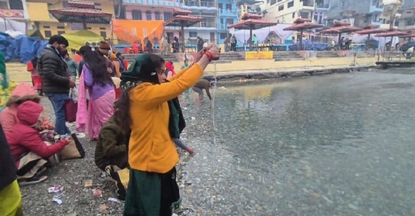 सूर्य को अर्घ्य अर्पित करती एक महिला।