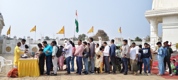 श्रद्धालुओं के बीच भोग प्रसाद का वितरण करते हुए ट्रस्ट के लोगों की तस्वीर