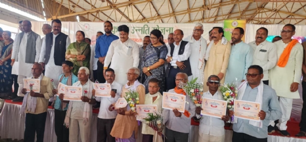 मंचस्थ अतिथि के साथ खड़े हुए किसान।