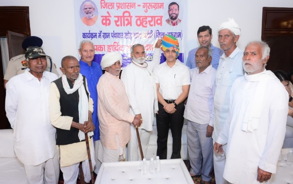 गुरुग्राम के गांव खोड़ में रात्रि ठहराव के दौरान उपायुक्त अजय कुमार का स्वागत करते ग्रामीण।