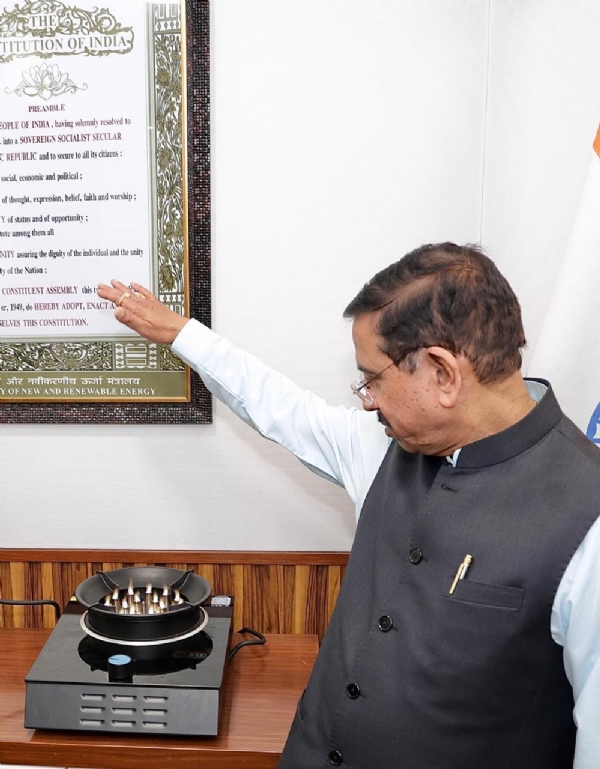 केंद्रीय मंत्री प्रह्लाद जोशी इलेक्ट्रिक स्टोव दिखाते हुए।
