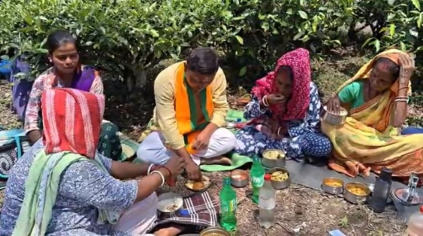 बीजेपी उम्मीदवार आनंदमय बर्मन महिला चाय श्रमिकों के साथ भोजन करते हुए