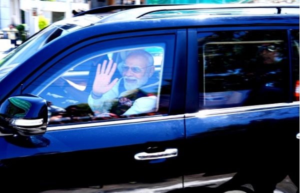 प्रधानमंत्री नरेन्द्र मोदी रोड शो के दौरान हाथ हिलाकर लोगों का अभिवादन स्वीकार करते हुए।