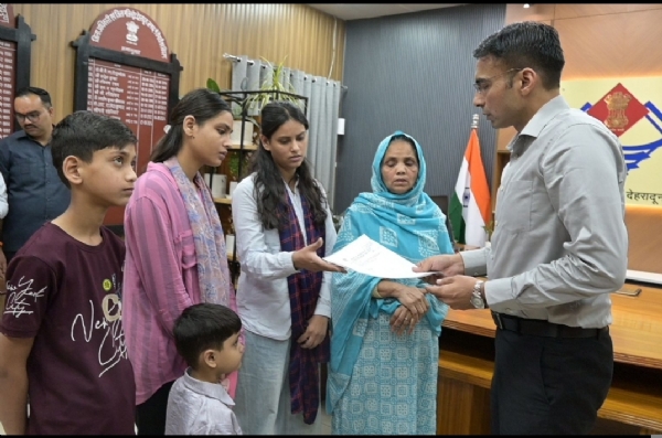 देहरादून जिलाधिकारी सविन बंसल  विधवा के परिजन  के साथ।