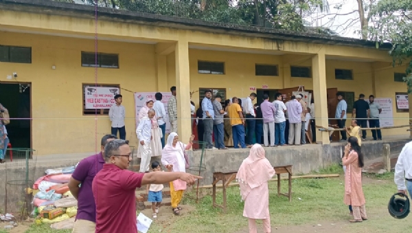 असम चुनाव 2026: गुवाहाटी के बरसोजाई हाई स्कूल मतदान केन्द्र पर गुरुवार को बरसात के बीच मतदान करने के लिए कतारबद्ध मतदाता