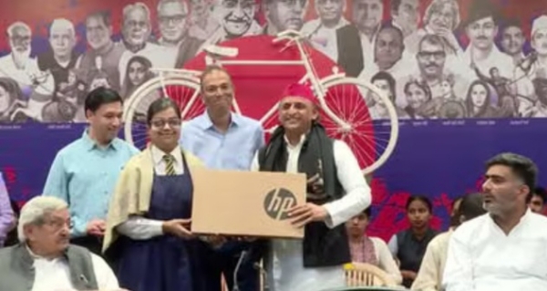 सपा अध्यक्ष अखिलेश यादव मेधावी छात्रा को लेपटॉप भेंट करते हुए।