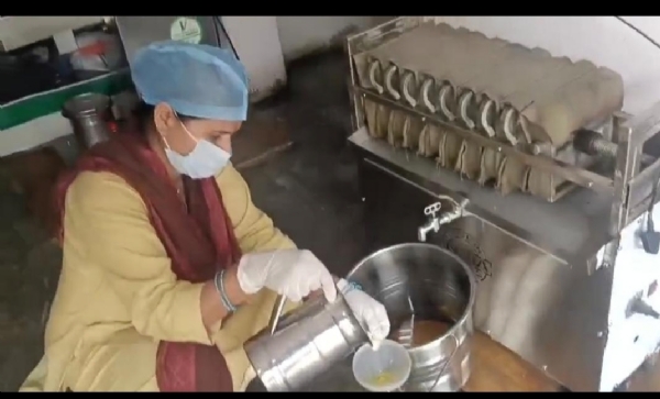 मशीन से तेल निकलती महिलाएं। मशीन से तेल निकलती महिलाएं।