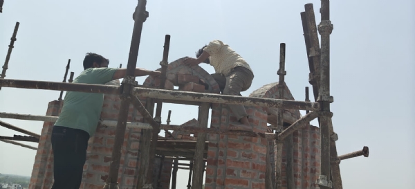 मीनार को तोड़ते मजदूर
