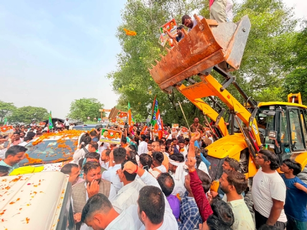 प्रदेश अध्यक्ष पंकज चौधरी पर जेसीबी से पुष्पवर्षा करते कार्यकर्ता