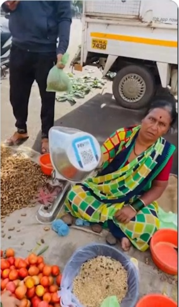 सब्जी विक्रेता क्यूआर कोड के माध्यम से भुगतान स्वीकार करते हुए सब्जी विक्रेता क्यूआर कोड के माध्यम से भुगतान स्वीकार करते हुए