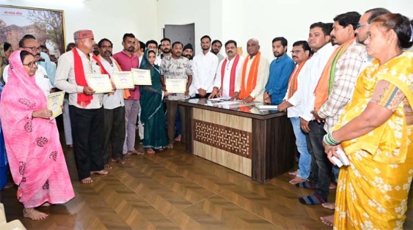 उप मुख्यमंत्री विजय शर्मा हितग्राहियों को आवास निर्माण के लिए स्वीकृति पत्र प्रदान करते हुए
