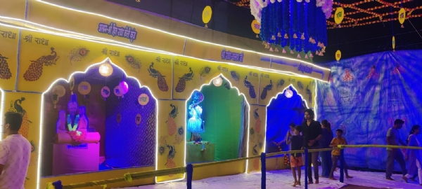 गणेश पंडाल के पास बनाई गई वृंदावन झांकी को देखते हुए लोग। गणेश पंडाल के पास बनाई गई वृंदावन झांकी को देखते हुए लोग।