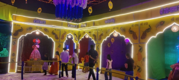 गणेश पंडाल के पास बनाई गई वृंदावन झांकी को देखते हुए लोग। गणेश पंडाल के पास बनाई गई वृंदावन झांकी को देखते हुए लोग।