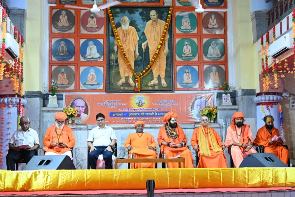 ‘लोकतंत्र की जननी है भारत’ विषयक सम्मेलन में विचार रखते प्रो. योगेंद्र प्रताप सिंह एवं मंचासीन संत-महात्मा।